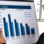 ** Confident job candidate presenting quantified achievements (e.g., charts showing cost reduction or efficiency gains) during a salary negotiation meeting. Focus on professionalism and data-driven arguments.

**